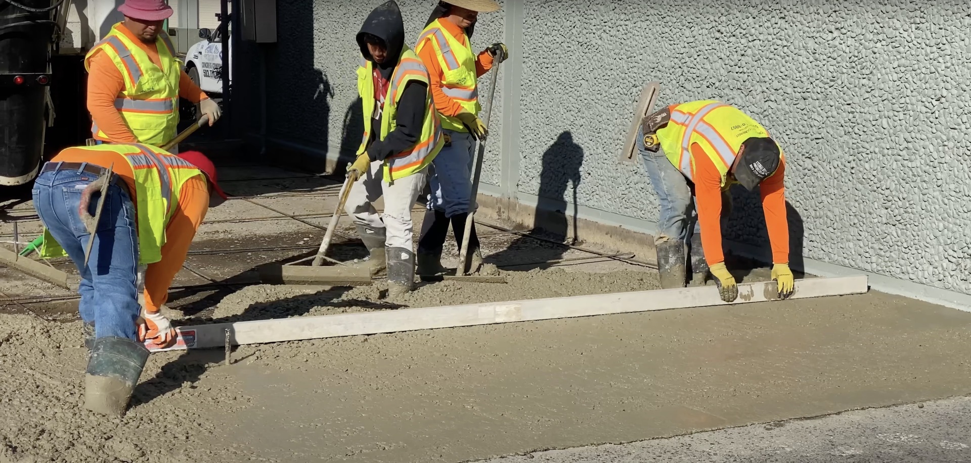 Professional concrete contractors smoothing and finishing fresh concrete surface