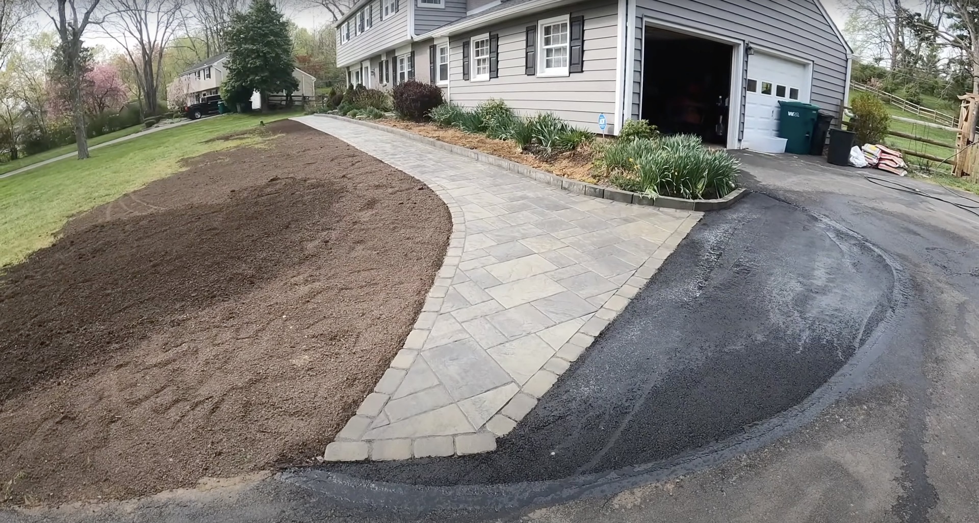 Curved concrete walkway and paver installation showing landscape integration