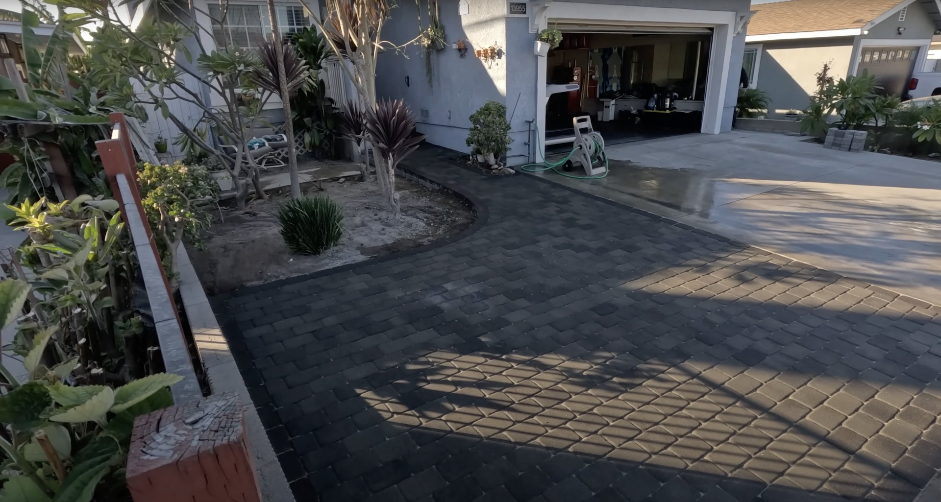 Beautiful completed concrete driveway and landscaping project in residential setting
